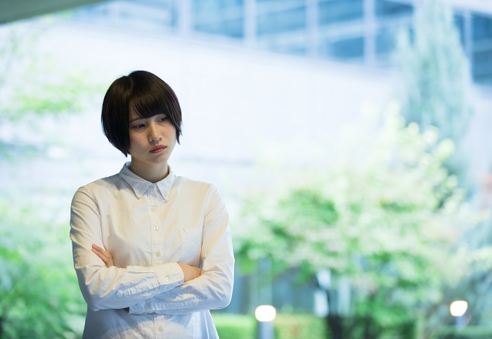 Woman standing near window, worrying