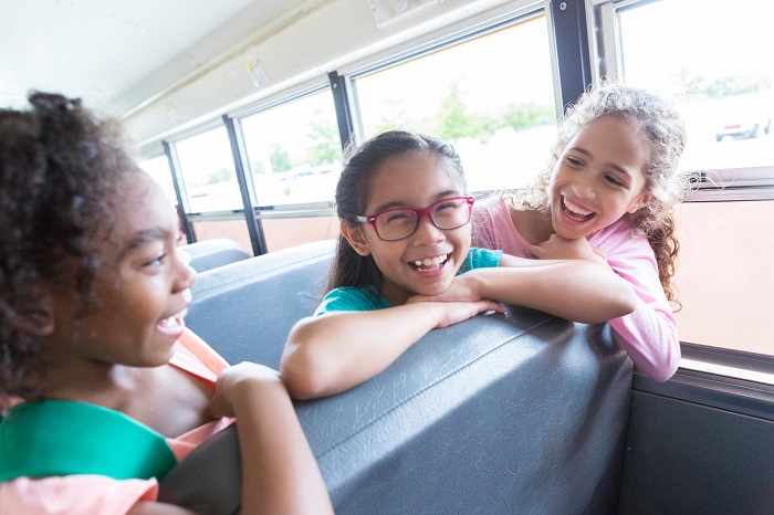 Group of girls laughing on a school bus