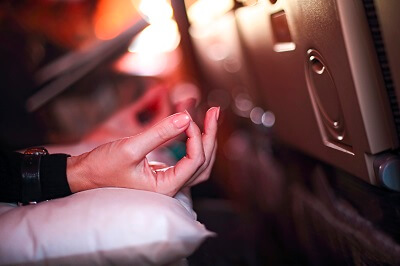 Woman's hands as she meditates on an airplane