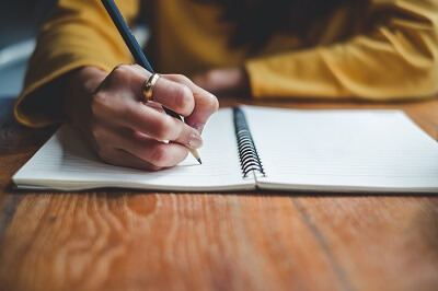 Woman's hand writing in a notebook