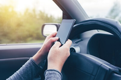 Closeup of person holding smartphone while driving