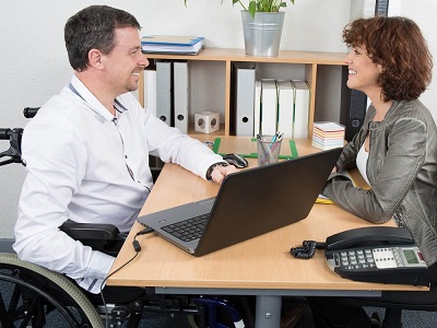 The owner of a group private practice interviews a candidate at a tiny table.