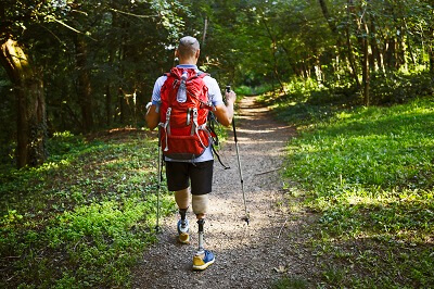 Man with two prosthetic legs hiking in forest