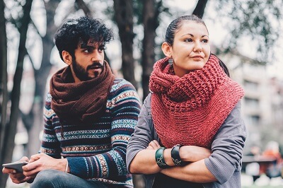 Couple in an argument sitting on a park bench