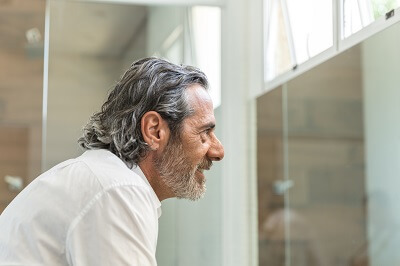 Older man looking at himself in the mirror