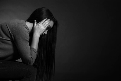 Woman sitting with her head in her hands