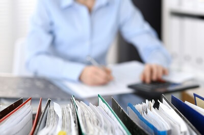 Professional working at desk with row of binders in the foreground