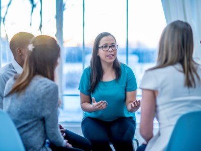 A woman tells a support group about her childhood.