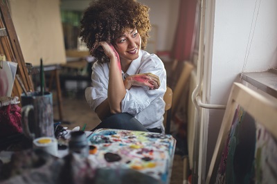 Artist with paint on hands, happy