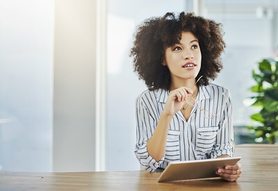 Woman holding a tablet, deep in contemplation