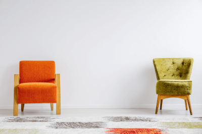Orange and green chair against a white wall