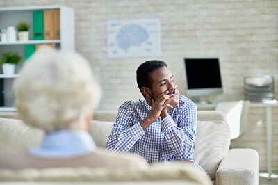 Man contemplating something in therapy, resting his chin in his hands