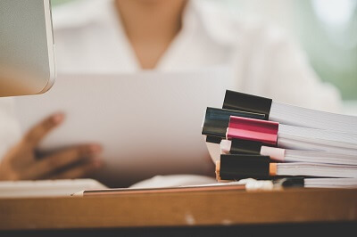 Stacks of documents and records sitting on a desk