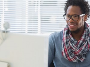 A fashionable therapist types at his computer