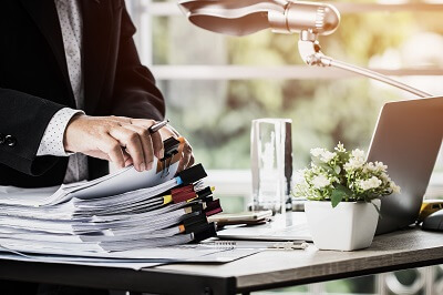 Sorting and organizing stack of papers on a desk