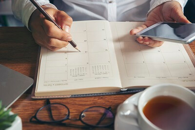 Hand filling out a calendar