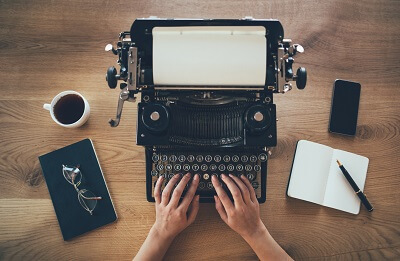 Hands typing on typewriter