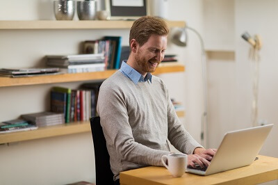 Smiling mental health professional working on his computer