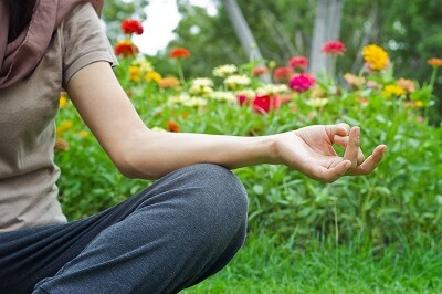 Individual meditating in a garden