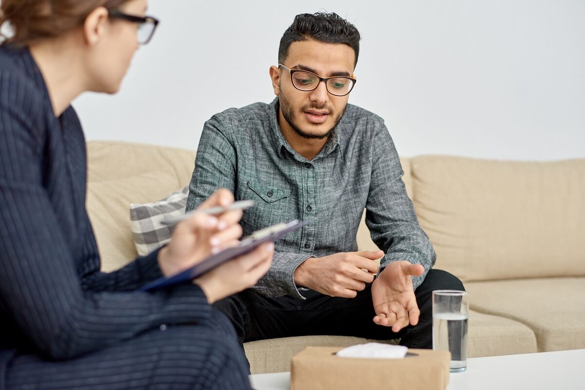 Homme assis sur un canapé et parlant à son thérapeute