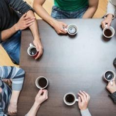 Group of friends sit and drink coffee
