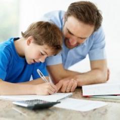 A man helps his son with homework. 