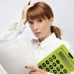 Stressed business woman holding oversized report and calculator