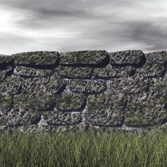 A stone wall cuts through the country-side, while stormy clouds hover above.