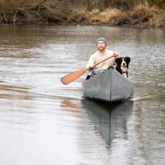 Young man and his dog canoeing