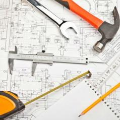 Construction tools are scattered over a blueprint.