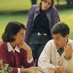 Parents talk while teen watches in background