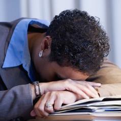 Stressed woman placing her head on her desk