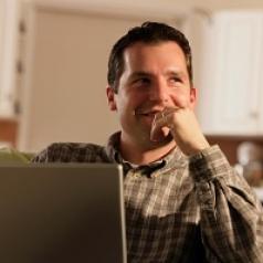 man-smiling-while-using-laptop
