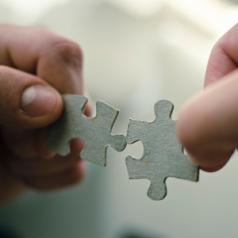 hands-trying-to-fit-two-puzzle-pieces-together