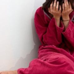 woman crying on floor in bathrobe