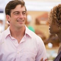 man smiling while woman speaks
