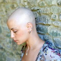 woman with shaved head looking sad