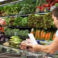 man reading shopping list in grocery store