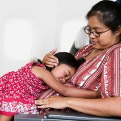 Mid adult woman holding a young girl in an airplane