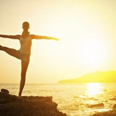 woman doing a yoga stretch at sunset