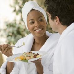 Couple in bathrobes, eating at health spa