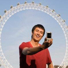 Man taking picture by ferris wheel