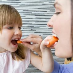 woman and little girl eating carrots