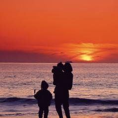 parent with children on beach