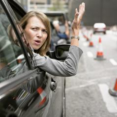 Anoyed Woman Looking Out Her Car Window Gesturing