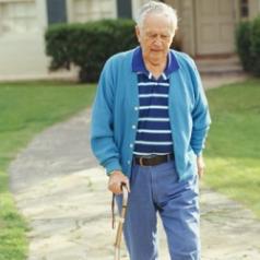 An elderly man walks away from his home