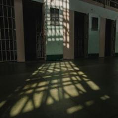 Sunlight floods an empty prison cell block