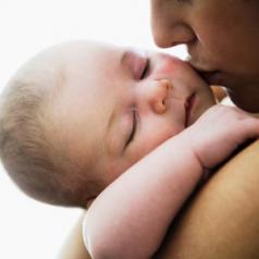 Mother kissing sleeping infant