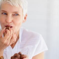 A senior woman enjoys chocolate