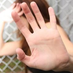 A woman holds her hand up in self-defense